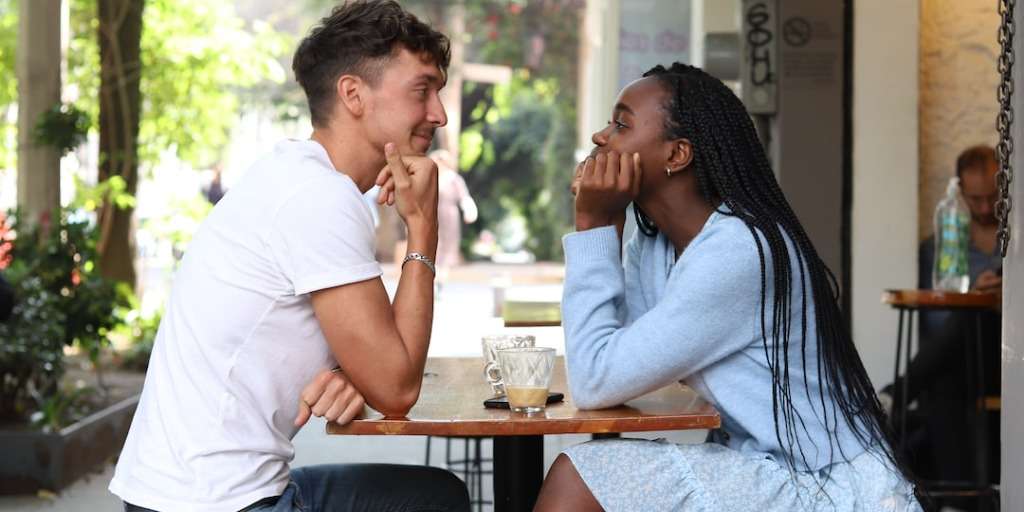 Two individuals enjoying a cafe date after following the Tinder profile guide for a successful match.