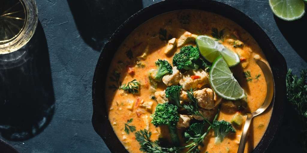 Delicious creamy curry dish with chicken, broccoli, and lime, showcasing some of the Foods in SA affecting health.
