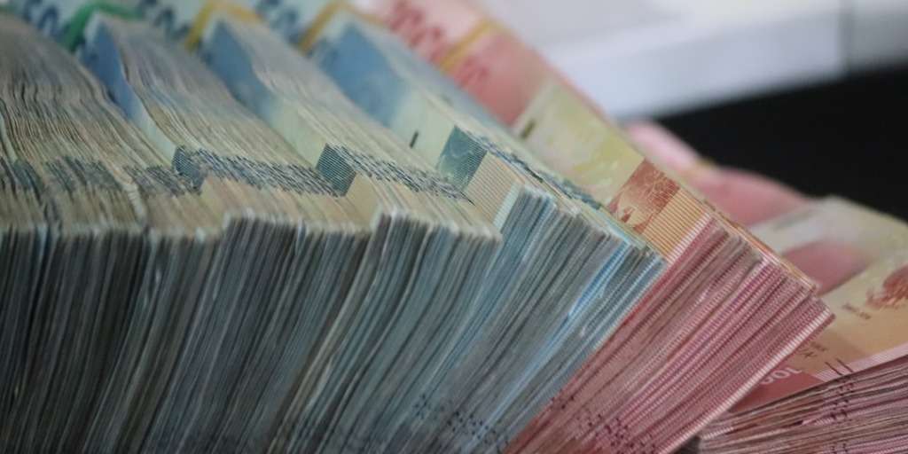 Stack of various denomination banknotes related to SASSA payments fanned out.
