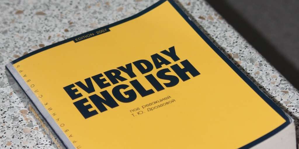 A 'Everyday English' textbook on a desk, an essential resource for learners aiming to Speak New Language Quickly and integrate into daily conversations.
