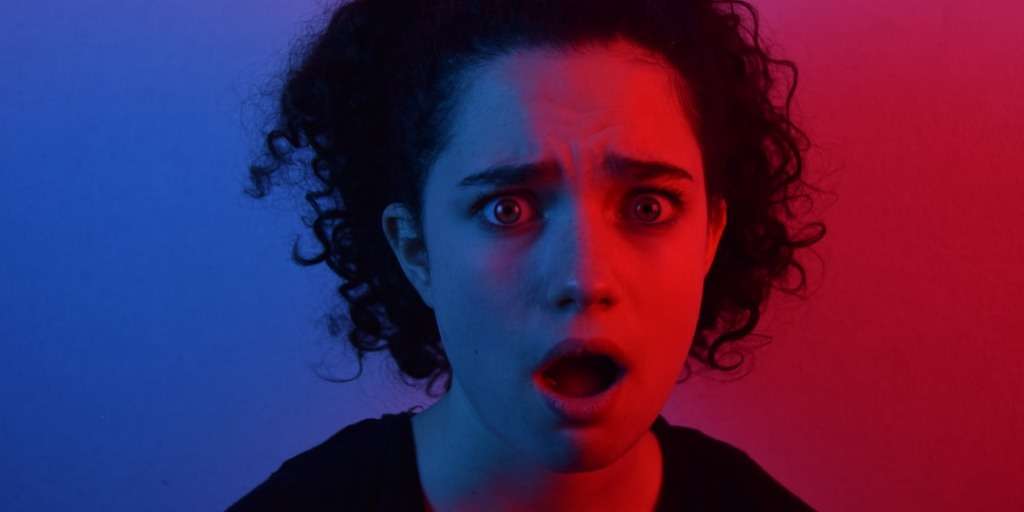 Woman looking shocked with a blend of blue and red lighting — Daily Planning App moment of surprise.