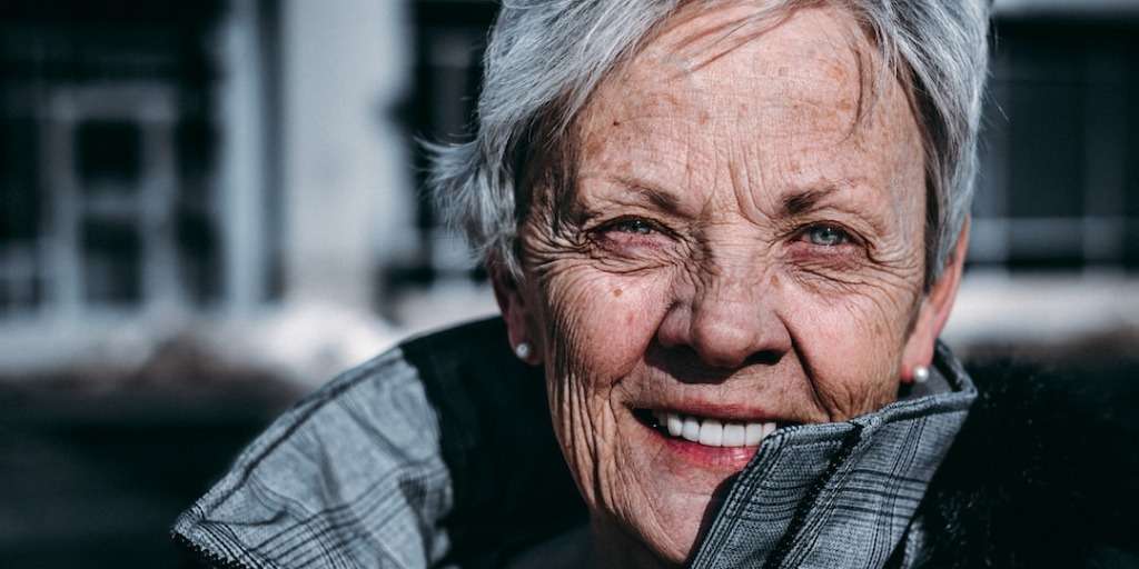 A cheerful elderly woman with a radiant smile, embodying the spirit of a 90-year-old with a winning lottery strategy.