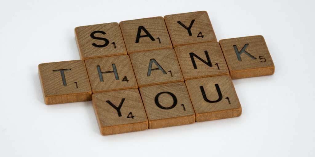 Wooden tiles spell "SAY THANK YOU," a visual representation from an etiquette guide.