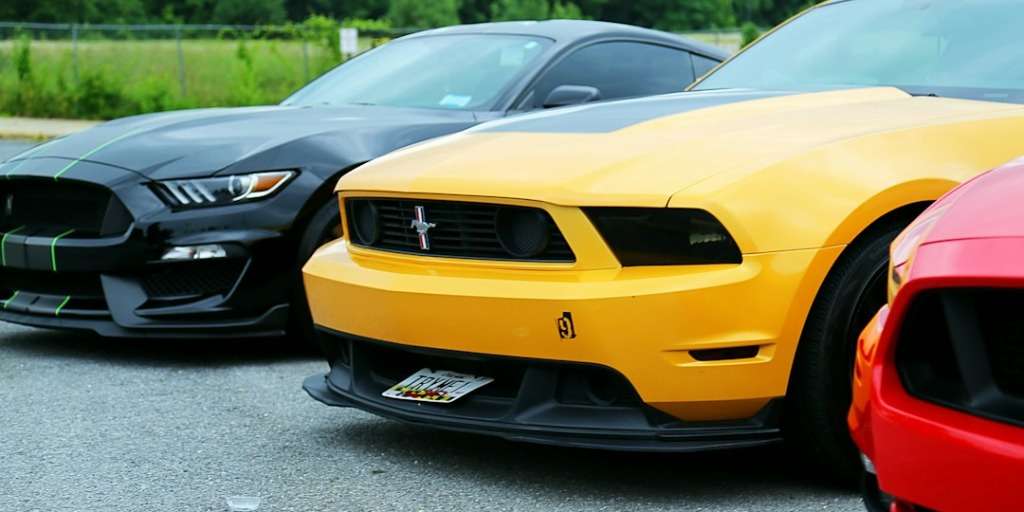 Yellow and black petrol cars parked side by side, showcasing muscular automotive design and power.