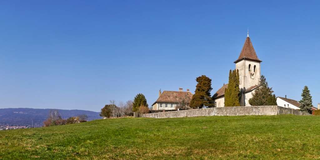 Village Renewable Energy Pioneer church and houses on a sunny hill with clear blue skies.