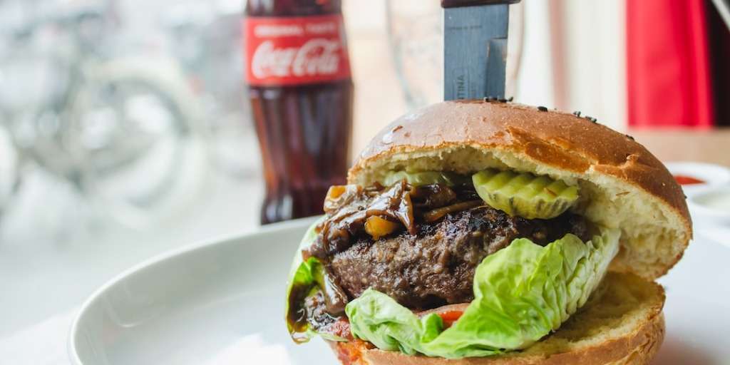 A burger with lettuce and pickles, hinting at the shocking truth about everyday foods.