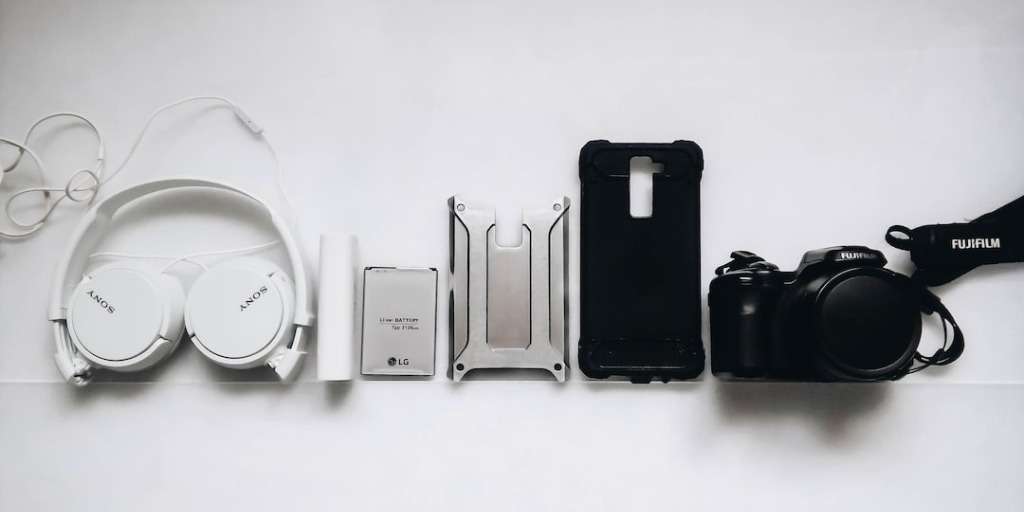 Assorted gadgets to boost your productivity exponentially: headphones, battery pack, smartphone, stand, and camera.
