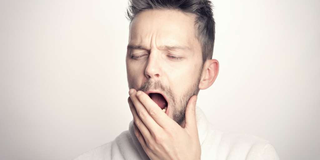 Man yawning tiredly, seeking A Natural Remedy for Insomnia, in need of restful sleep.