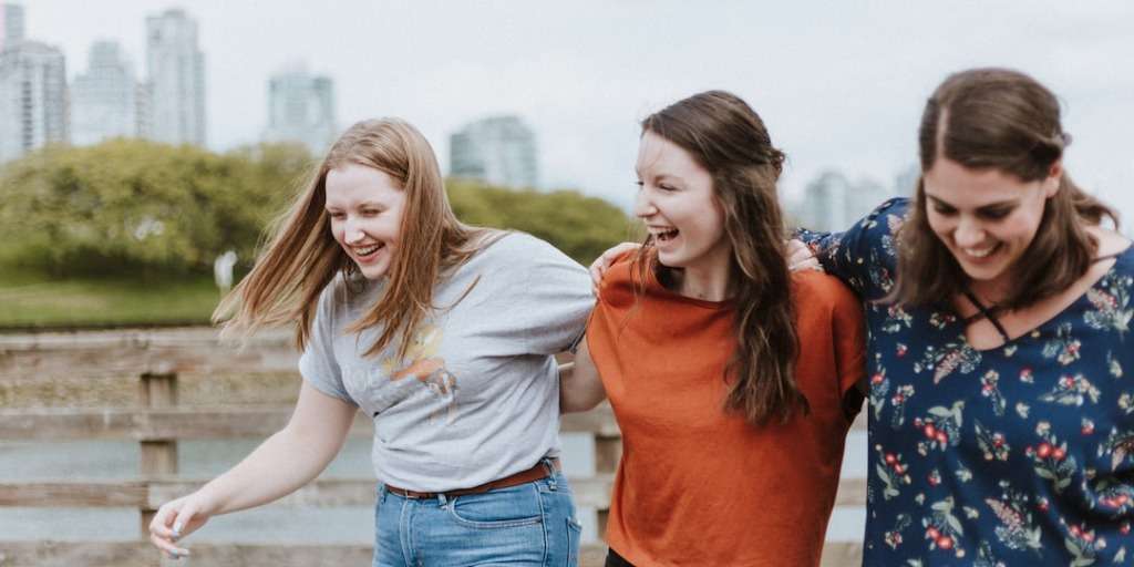 Group of friends laughing and walking, illustrating the power of the Psychological Trick to Instantly Win Friends.