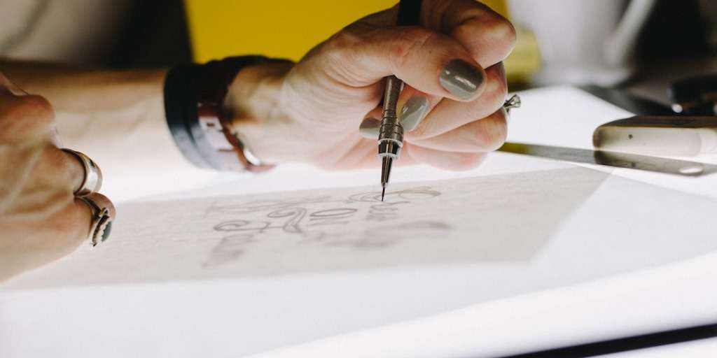Person sketching creative designs, exemplifying 'Be Creative in Your Workplace' ethos effectively.