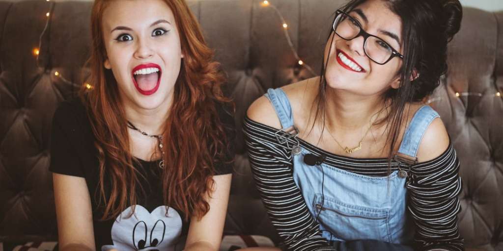 Two joyful teens on a couch, exemplifying successful 'Communicate with Your Teen' moments.