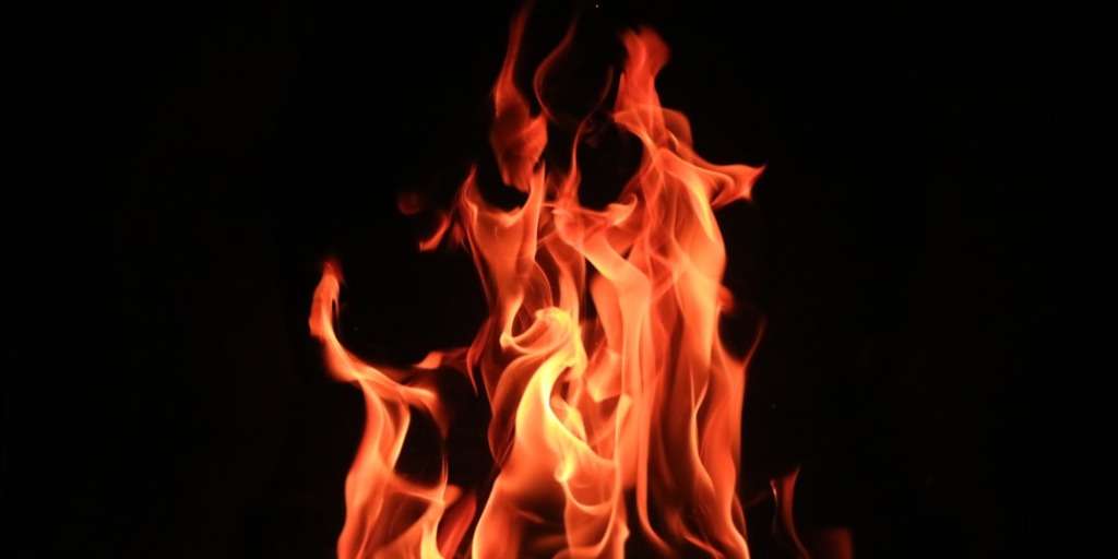 Intense orange flames dancing against darkness, highlighting "Home Fire Hazards" with caution and urgency.