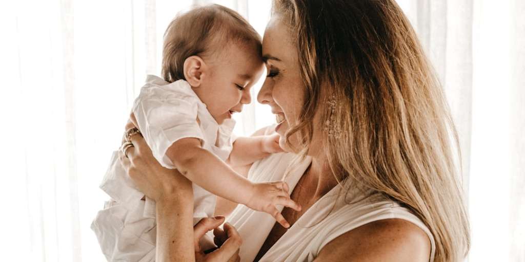 Stay-at-home mum lovingly holding her baby, showcasing the bond and fulfilment in their relationship.