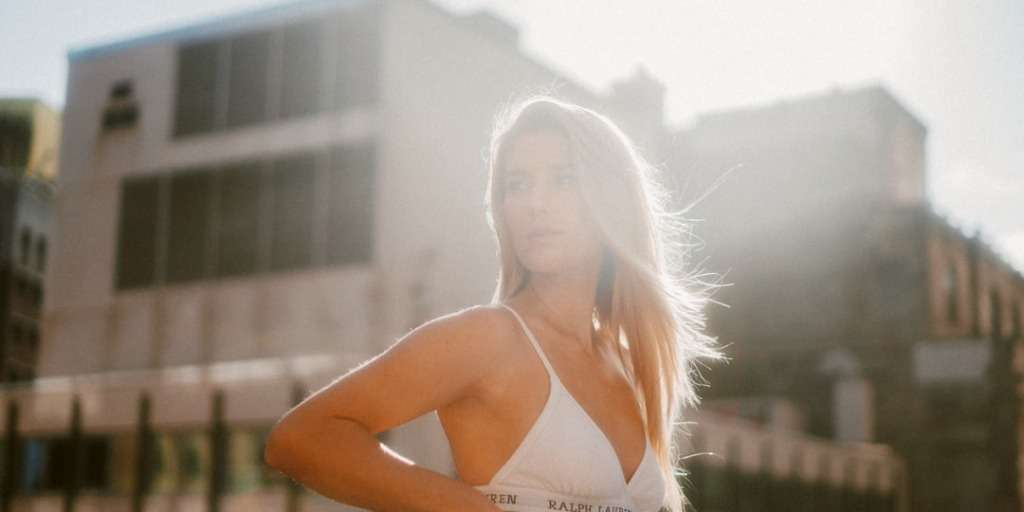 Woman basking in the sunlight, showcasing how to get the summer tan with healthy glowing skin.