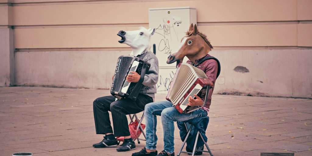 Two people wearing horse masks playing accordions. Funniest World Records in a street performance setting.