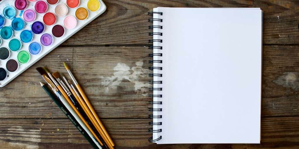 a paint board and notebook, symbolising creative hobbies.